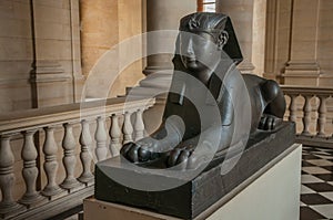 Ancient sculpture of Egyptian sphinx sitting at the Louvre Museum in Paris.